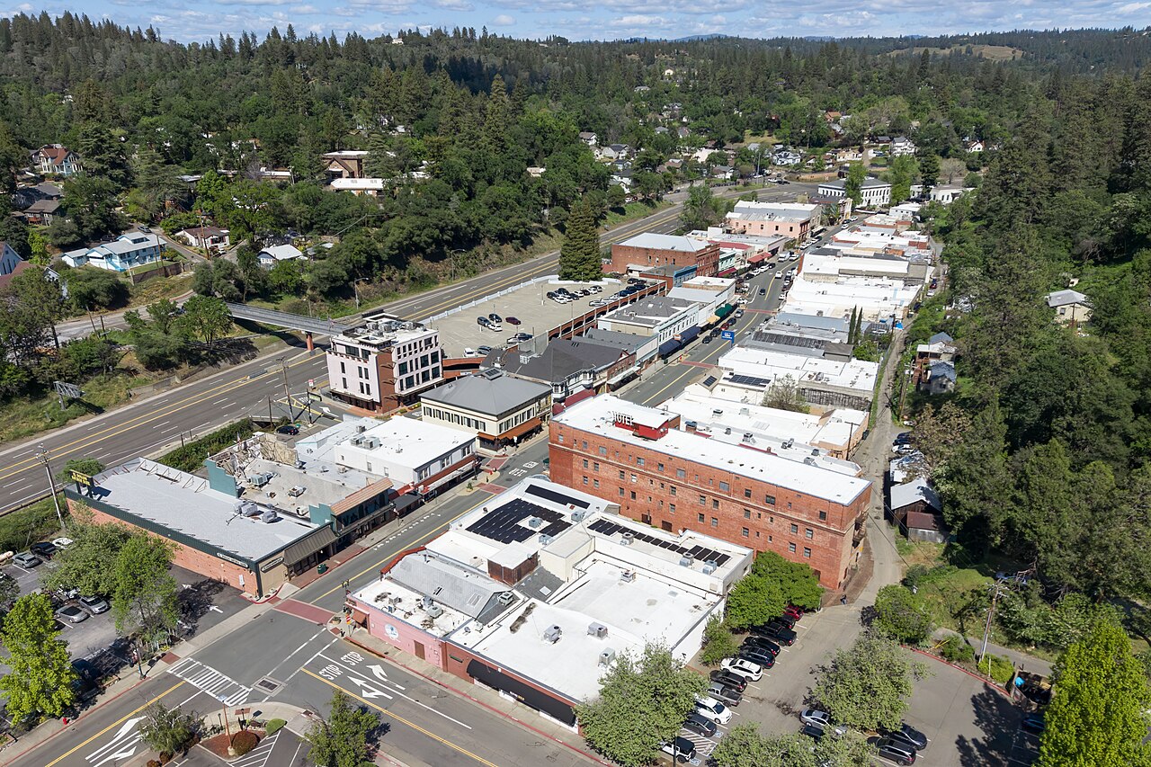 Aerial view of downtown Placerville, California, with tree-covered hills around the town